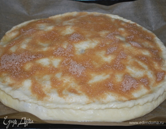 Взбейте яичный белок. В чашке соедините 2 ст. ложки сахара и 1 ч. ложку молотой корицы. Раскатайте в тонкий пласт вторую часть теста, сформируйте пирог. Верх смажьте взбитым яичным белком с помощью кулинарной кисти, посыпьте сахаром с корицей. Выпекайте в предварительно разогретой духовке при 170°C 40–45 минут, до готовности.