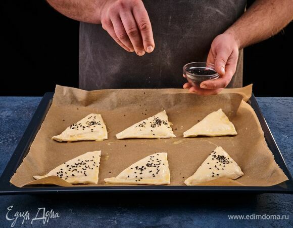 Посыпьте кунжутом. Запекайте в разогретой до 180°С духовке около 25 минут.