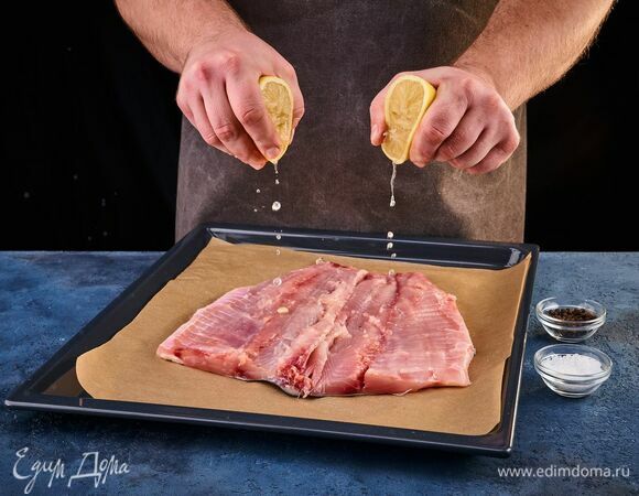 Рыбу, очищенную от чешуи, разрежьте по спине вдоль хребта, удалите кости, и разверните, как книжку. Противень застелите фольгой или пергаментом, выложите рыбу кожей вниз. Посолите, поперчите, сбрызните лимонным соком.