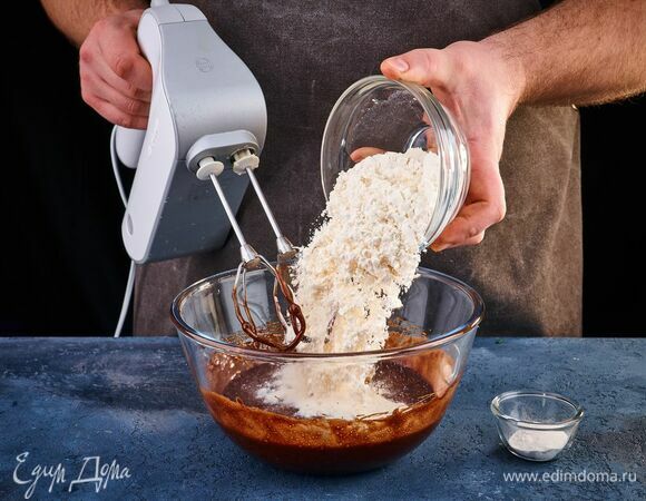 Взбейте миксером, чтобы масса увеличилась в объеме в 1,5–2 раза и немного посветлела. Добавьте просеянную муку с разрыхлителем. Замесите тесто.