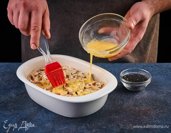 Яйцо взбейте вилкой. С помощью кулинарной кисти смажьте этой смесью рулет. Посыпьте сверху кунжутом и запекайте в разогретой до 200°С духовке около 20 минут.