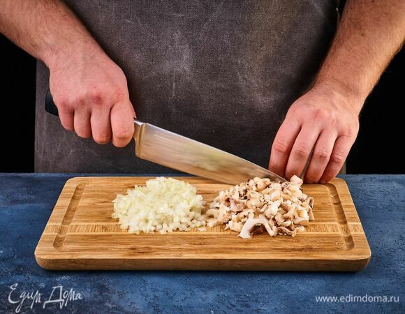 Шампиньоны почистите. Ножки грибов отрежьте и мелко порубите. Лук почистите и мелко нарежьте.