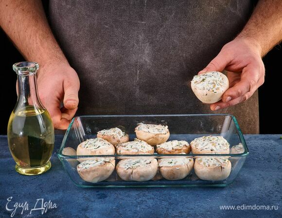 Выложите фаршированные грибы в форму для запекания, смазанную маслом.<br />
Запекайте в разогретой до 200°С духовке около 15 минут.