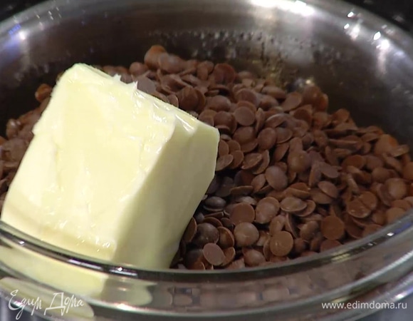 Шоколадные капли с оставшимся сливочным маслом растопить на водяной бане и перелить в глубокую миску, вмешать ванильный экстракт, затем, постоянно помешивая, частями ввести взбитые яйца.