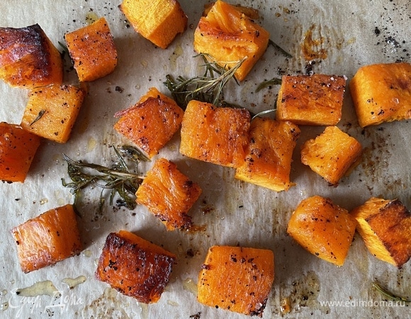 Тыкву очистите и нарежьте средними кубиками. Положите на противень, полейте оливковым маслом, добавьте веточку розмарина (я тыкву сверху посыпала красным сладким перцем). Запекайте тыкву при 180°C до мягкости.