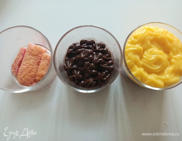 На дно стеклянных креманок выложить один слой печенья, предварительно окунув его в пропитку. Сверху выложить слой шоколадного крема. Затем снова слой печенья, окунув его в пропитку, и светлый крем. Десерт накрыть пищевой пленкой и поставить в холодильник до использования.