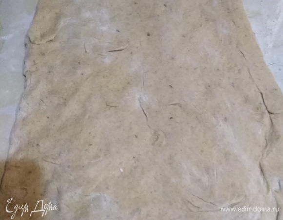 Раскладываем руками без применения скалки пласт 30*40 см. Стряхиваем излишки муки. Складываем тесто в три раза.