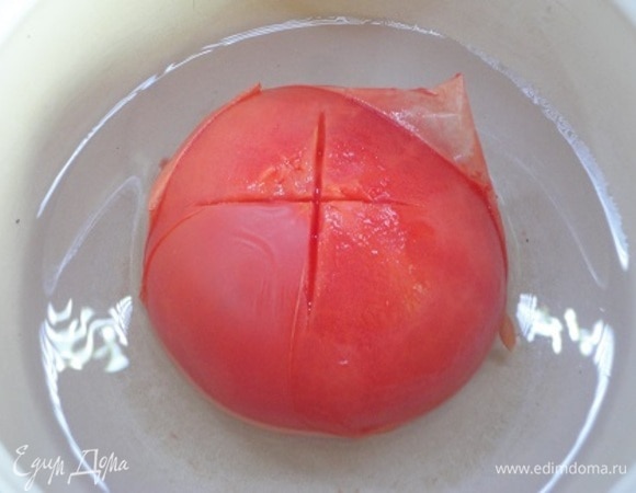 На каждом помидоре сделайте крестообразные надрезы, залейте кипятком примерно на 30 секунд, после чего обдайте холодной водой и снимите кожицу.