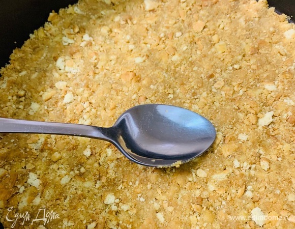 Выложить массу в форму и, надавливая, сформировать плотный равномерный нижний слой.