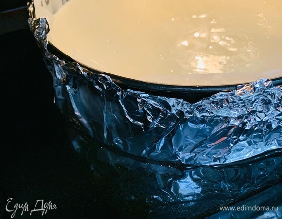 Поставить форму с чизкейком на противень. Залить противень кипящей водой до краев.