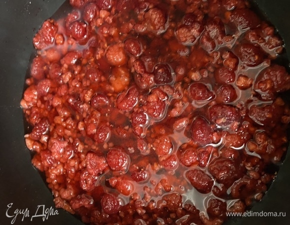 Готовим соус. Замороженную малину посыпаем сахаром, добавляем к ней воду и варим на среднем огне минут 10.