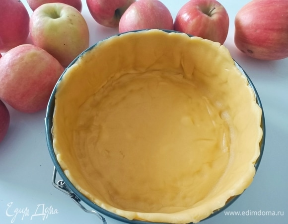 Желтки соединить с сахарной пудрой и щепоткой соли, слегка взбить. Добавить масло, просеянную муку и разрыхлитель. Замесить тесто. Разъемную форму диаметром 20–22 см застелить пергаментной бумагой. Раскатать тесто, выложить в форму и поставить в холодильник.