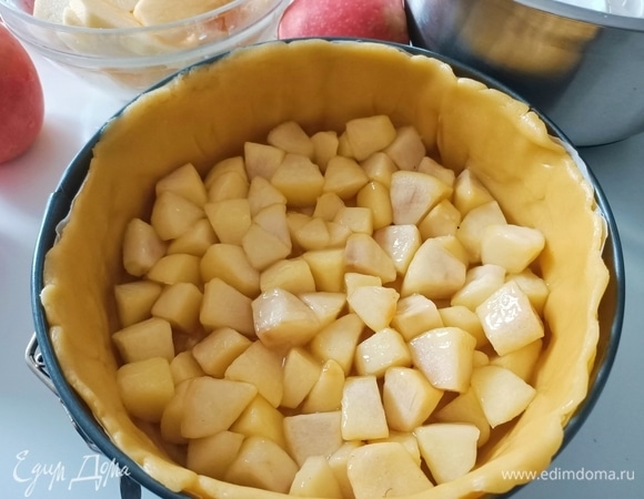 Достать форму с песочной основой из холодильника. На дно уложить карамелизированные яблоки.