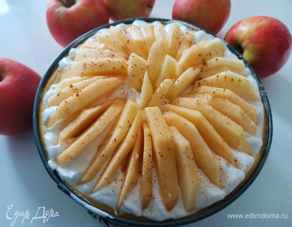 Поверх крема выложить дольки яблок. Посыпать корицей и отправить пирог в предварительно разогретую духовку до 180°C на 40–45 минут.