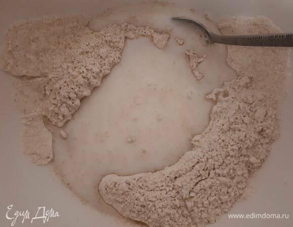 Смешайте муку, сахар, соль и дрожжи, влейте теплое молоко и теплую воду. Накройте плотным полотенцем и оставьте на полчаса.