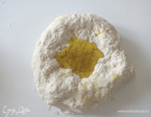 Соединить муку и воду. Замесить тесто. Затем добавить оливковое масло (25 г) и вымесить тесто еще раз.