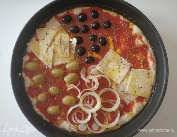 Сверху выложить протертые помидоры (для этого рецепта выжно использовать именно помидоры в собственном соку, а не томатный соус или кетчуп). Сверху томатов уложить начинку (она может быть разнообразной — все, что вы любите). Посыпать розмарином, приправой для пиццы и щедро полить оливковым маслом.