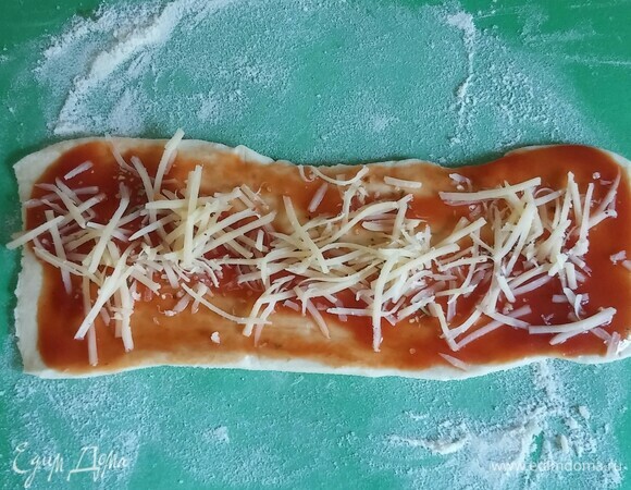 Посыпать прямоугольники тертым сыром и приправой для пиццы.