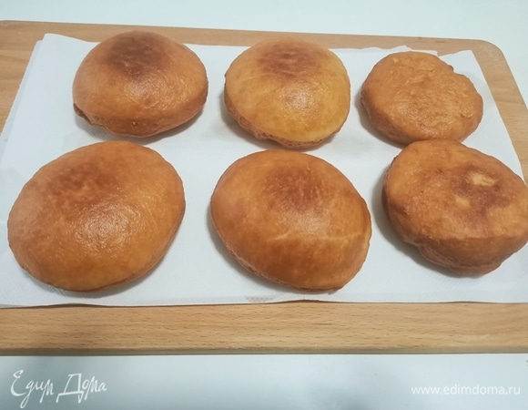 Нагреть растительное масло до раскаленного состояния, оно должно тихонько потрескивать (в идеале его температура должна быть 180–190°C). Опускать пончики по одному в масло и, как только восстановится активное кипения масла, уменьшить огонь до среднего и жарить, переворачивая, до равномерного румянца.