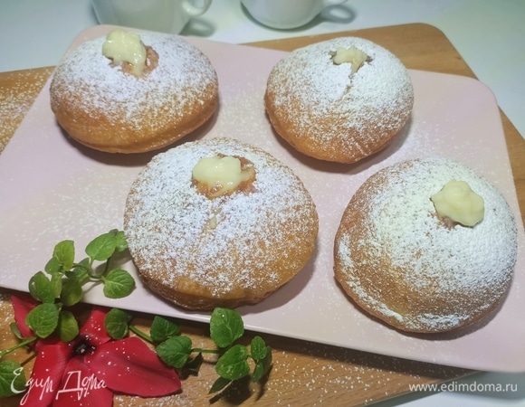 Выложить пончики на бумажное полотенце для удаления лишнего жира. Дать им немного остыть, а затем обвалять в сахаре или сахарной пудре. С помощью кондитерского мешка с острой концовкой наполнить выпечку заварным кремом. Приятного аппетита!