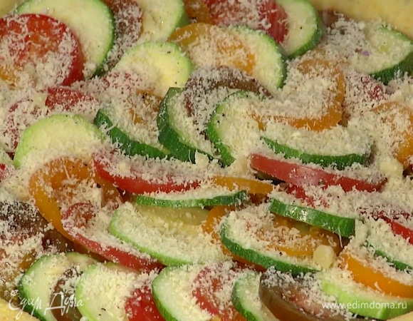 Все помидоры, цукини и кабачок нарезать кружками и уложить на тесто, слегка сбрызнуть оливковым маслом, посолить и поперчить, посыпать пармезаном. Края теста завернуть внутрь и смазать желтком, смешанным со щепоткой соли.