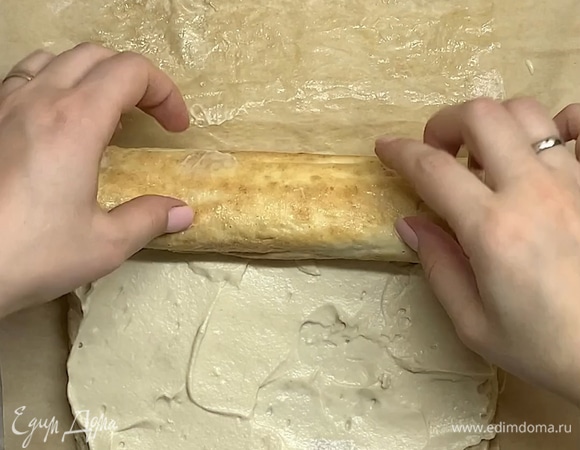 Готовим крем. В маскарпоне добавляем крепкий кофе, 30 г сахарной пудры и взбиваем однородный крем. Разворачиваем рулет, смазываем обильно кремом и закручиваем.