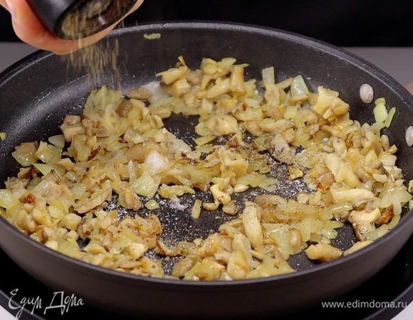 В сковороде разогреваем растительное масло, высыпаем лук и обжариваем в течение минуты. Он должен стать полупрозрачным. Теперь добавляем грибы и обжариваем до готовности. В самом конце по вкусу всыпаем соль и черный молотый перец. Перемешиваем и даем грибам остыть.