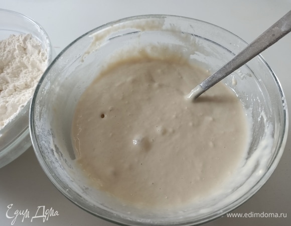 Добавить примерно 150–200 г муки. Перемешать. Накрыть пищевой пленкой и поставить в теплое место на 30 минут.