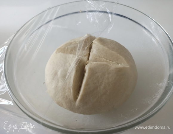 Ввести муку, замесить гладкое и эластичное тесто. Переложить в глубокую миску. Накрыть пищевой пленкой.