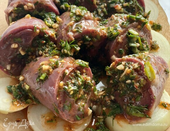 Лук нарезать шайбами, переложить в форму для запекания. Поверх лука выложить фаршированные сердечки и полить оставшимся маринадом.