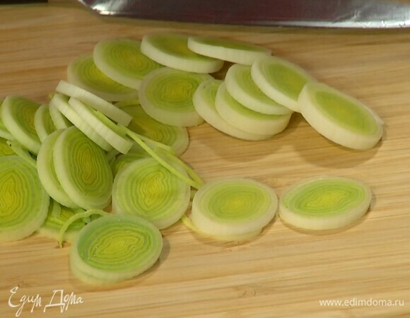 Светлую часть лука-порея нарезать тонкими кольцами.