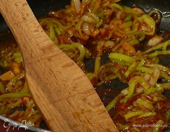Разогреть в сковороде оливковое масло и обжарить порей до золотистого цвета, затем добавить чеснок, томатную пасту, все слегка посолить, перемешать и обжарить.