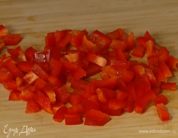 Весь сладкий перец разрезать пополам вдоль, удалить плодоножки с семенами, половинку одного перца нарезать маленькими кубиками, добавить к луку с чесноком и перемешать.