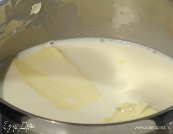 В кастрюлю влить молоко и 1/2 ч. ложки ванильного экстракта, добавить 100 г предварительно размягченного сливочного масла и растопить все на маленьком огне, не доводя до кипения.