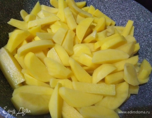 Картофель почистить, нарезать. Выложить в сковороду. Накрыть крышкой и на сильном огне жарить 5 минут.