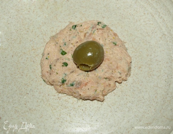 Из получившейся массы формируем лепешки и кладем в середину оливку без косточки. Формируем шарик.