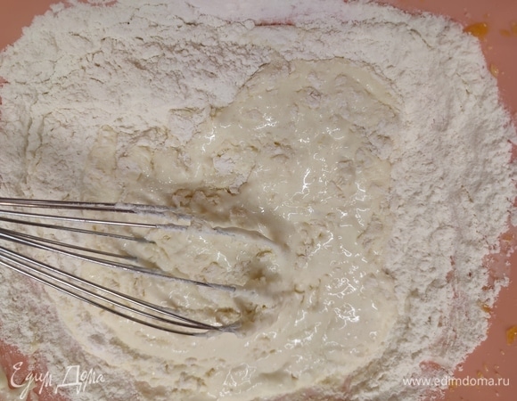 Ввести в желтковую смесь муку, соду, сметану, соль и растопленное сливочное масло. Перемешать до однородности.