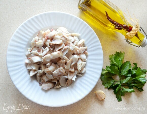 Готовую рыбу очистите от кожи и костей. Руками разберите на небольшие кусочки. К рыбе добавьте измельченный чеснок, мелко рубленую петрушку, приправьте перцем, сбрызните оливковым маслом и перемешайте.