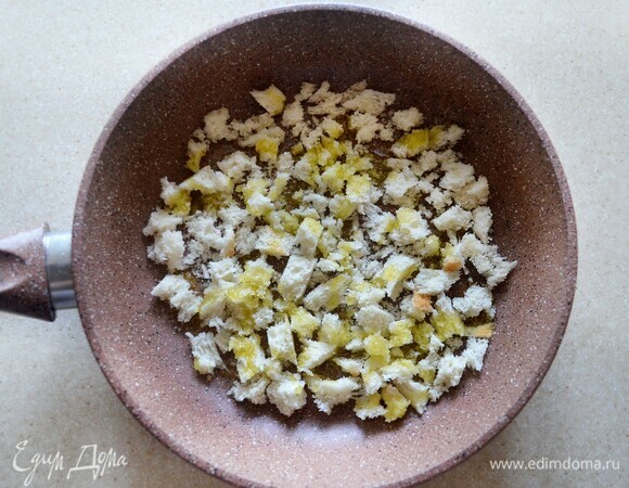 Мякоть черствого белого хлеба измельчите в крупную крошку, слегка обжарьте на оливковом масле до золотистого цвета.