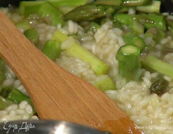 Спаржу, удалив грубые черенки, разрезать на 3-4 части, добавить в ризотто, все посолить, влить половник бульона, перемешать и прогревать еще 7 минут.