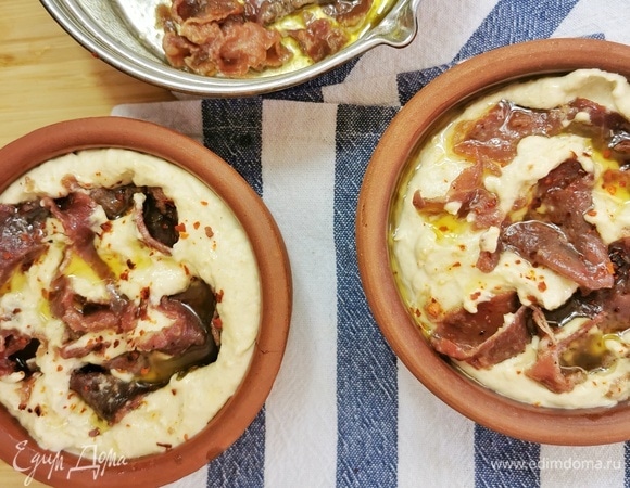 Затем красиво выкладываем мясо в горшочки, некоторые кусочки погрузите глубже внутрь хумуса. Обильно залейте растопленным сливочным маслом.