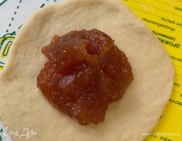 Каждый шарик теста сначала растянуть руками, потом слегка раскатать скалкой в кружок. Раскатывать слишком тонко не нужно, иначе тесто порвется и начинка вытечет наружу. В центр кружка выложите по 1,5– 2 ч. л. повидла. Соединить край теста и тщательно защепить. Выложить пирожки на застеленный пергаментом противень на расстоянии друг от друга. Накрыть и оставить на 20 минут.