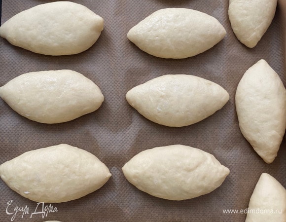 Желток смешать с молоком и добавить соль. Смазать пирожки этой смесью. Затем поставить в разогретую до 180°C духовку и выпекать до золотистого цвета, примерно 25 минут. Ориентируйтесь на свою духовку.