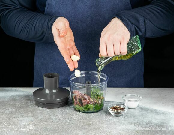 Влейте оливковое масло, добавьте чеснок, соль и перец.  Измельчите до однородной консистенции.