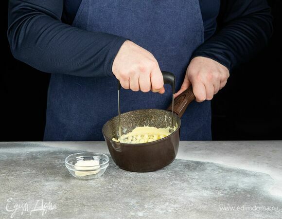 С картофеля слейте отвар, добавьте сливочное масло и разомните клубни толкушкой в пюре.