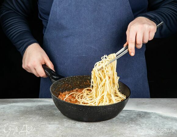 Отварите спагетти до готовности. Слейте воду. Добавьте пасту к соусу болоньезе, перемешайте.