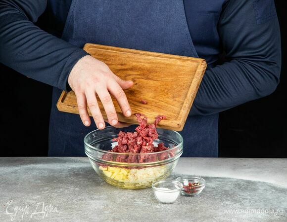 Добавьте мясо к картофелю и луку, посолите и поперчите.