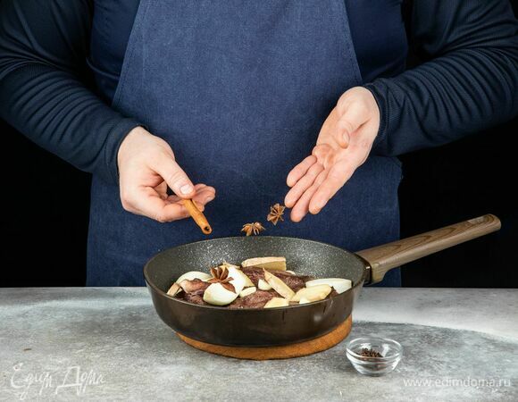 Выложите в сковороду вместе с обжаренными щеками. Добавьте гвоздику, бадьян, корицу.