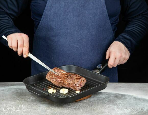Обжарьте мясо с чесноком на сковороде-гриль от 5 до 8 минут с каждой стороны до желаемой прожарки. Во время обжаривания стейк периодически переворачивайте.<br />
Готовое мясо подсушите полотенцем, чтобы убрать лишний сок. Нарежьте тонкими слайсами.