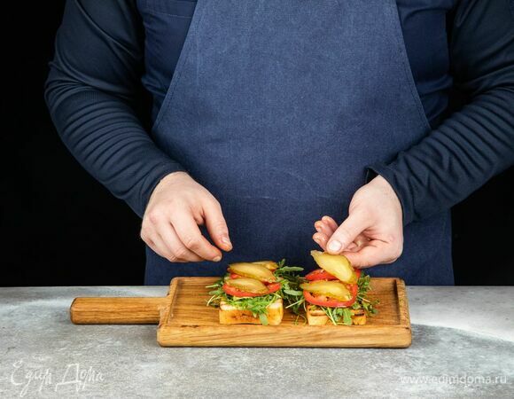 Затем выложите руколу, нарезанные помидоры и огурцы.